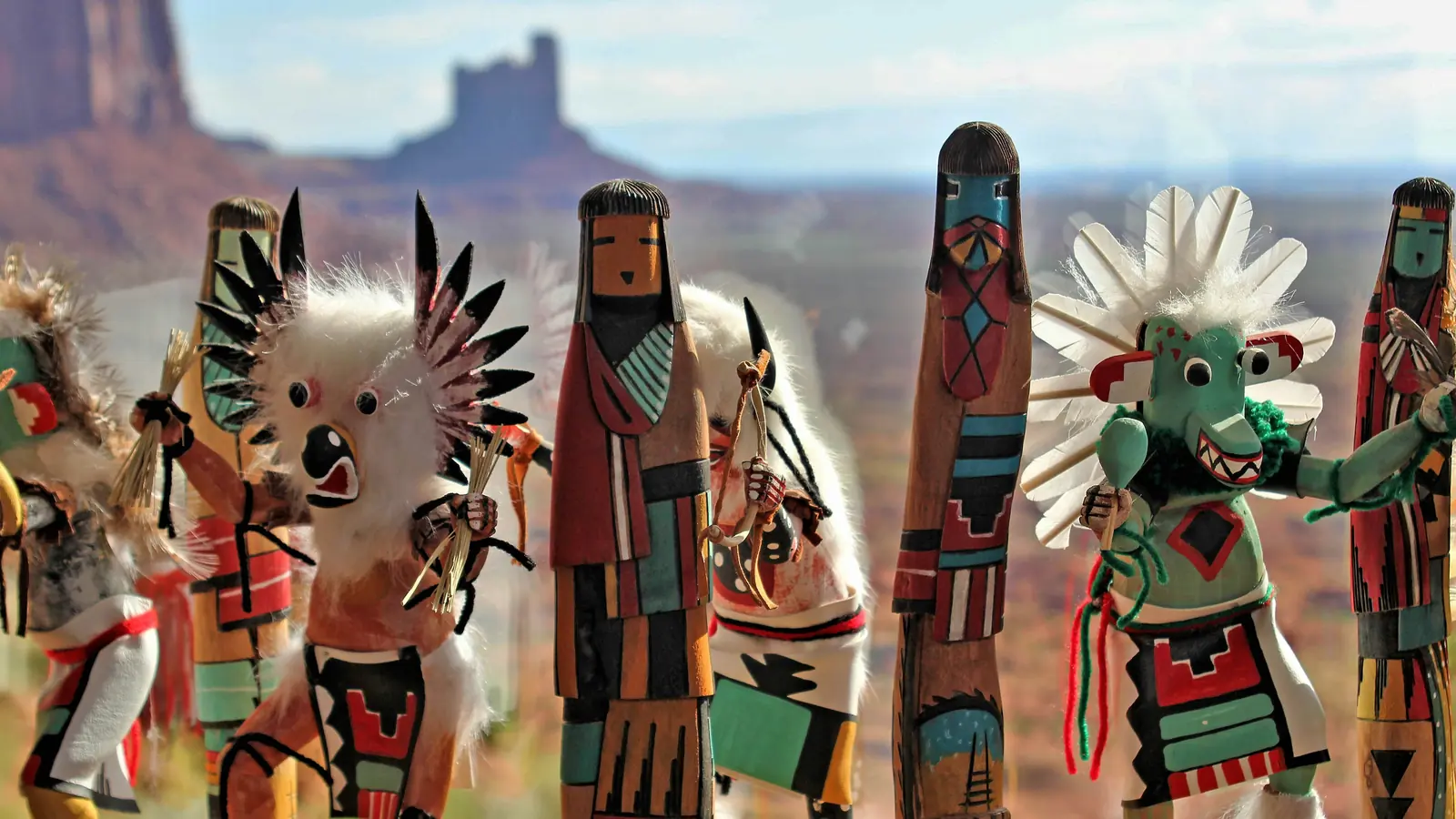 Hand-painted kachina figures against red-rock country