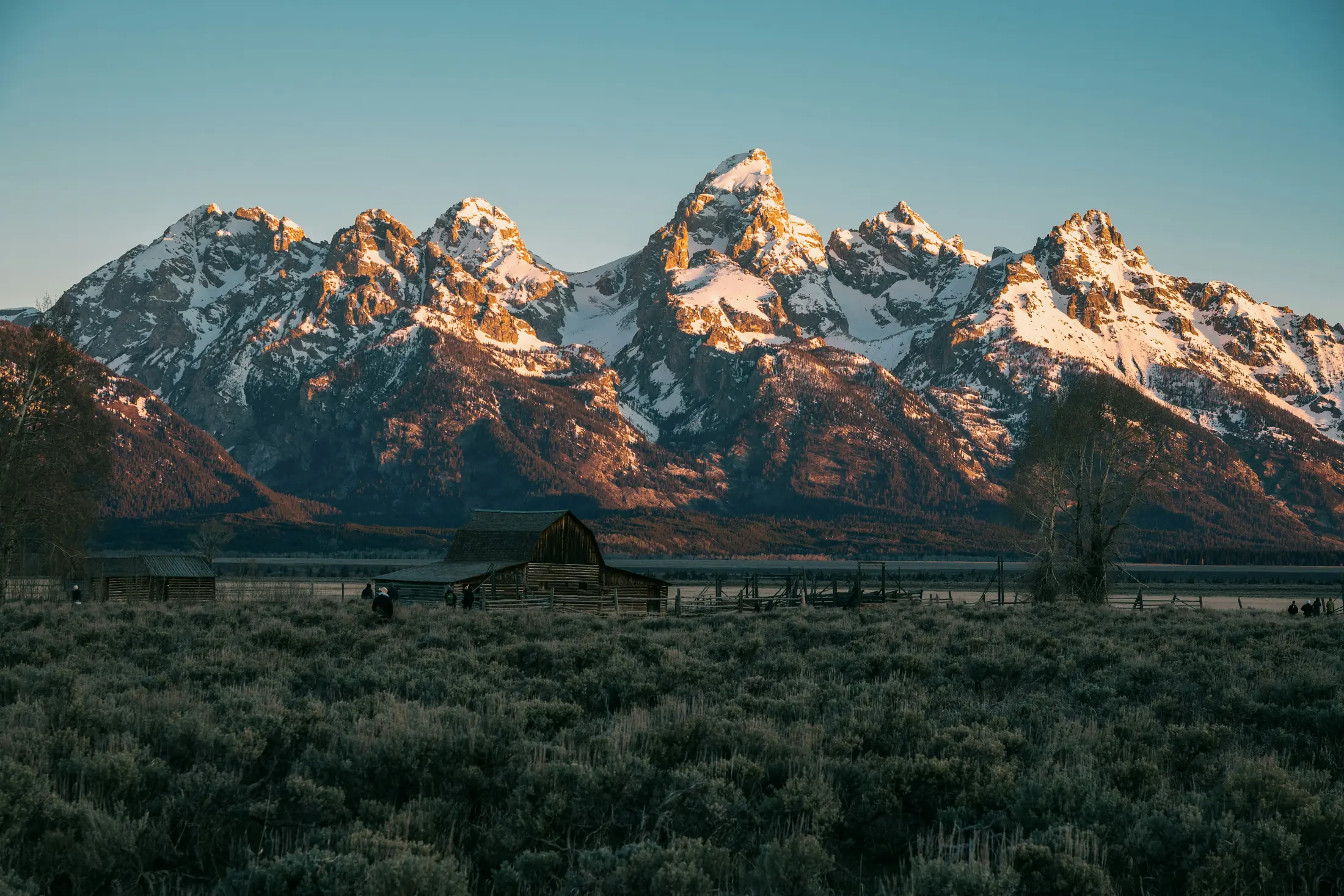 Sunlit Teton peaks above a quiet sagebrush valley
